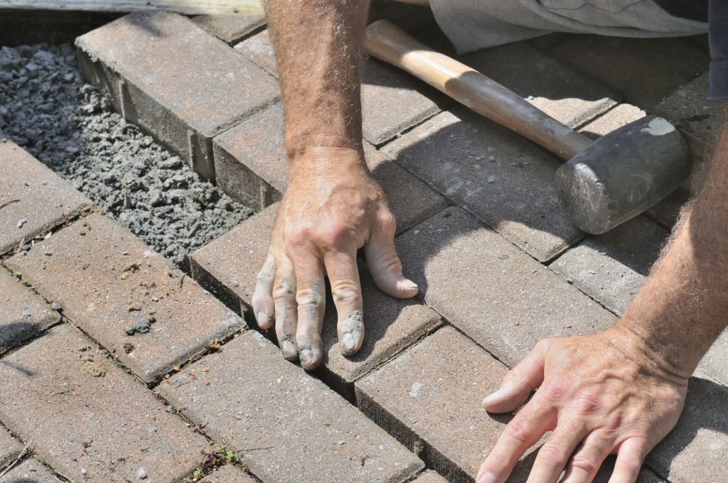 Photo of a man setting the paving stone